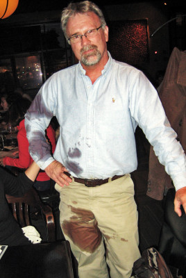 Man with red wine stains all over pants and shirt